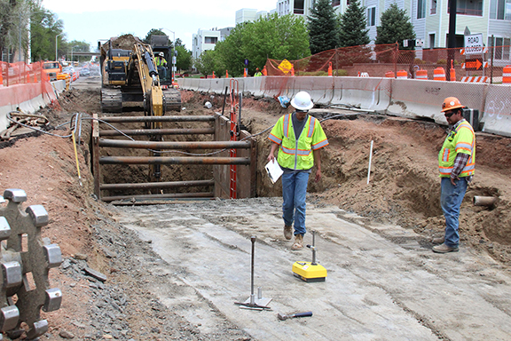 crews walking in construction site next to large hole